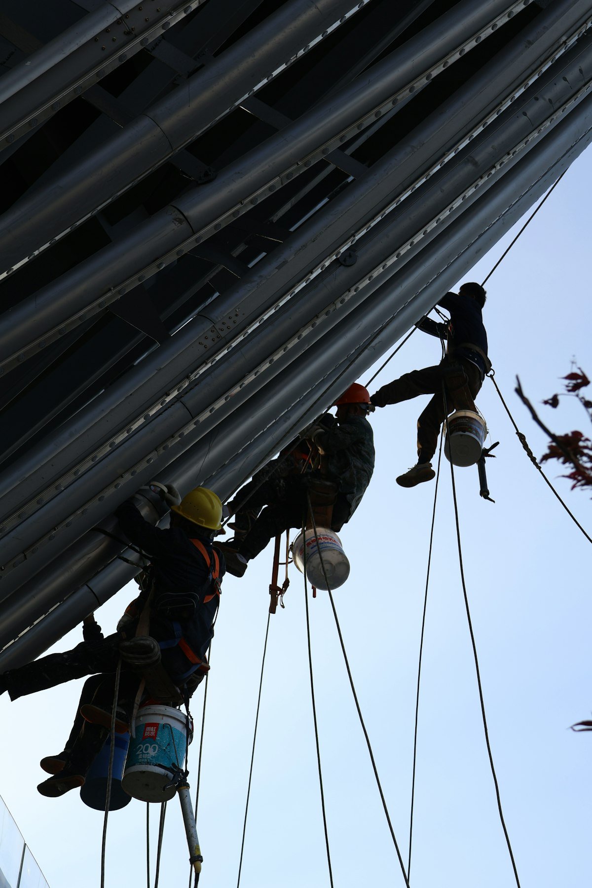 Rope-access workers in harnesses on a tall structure