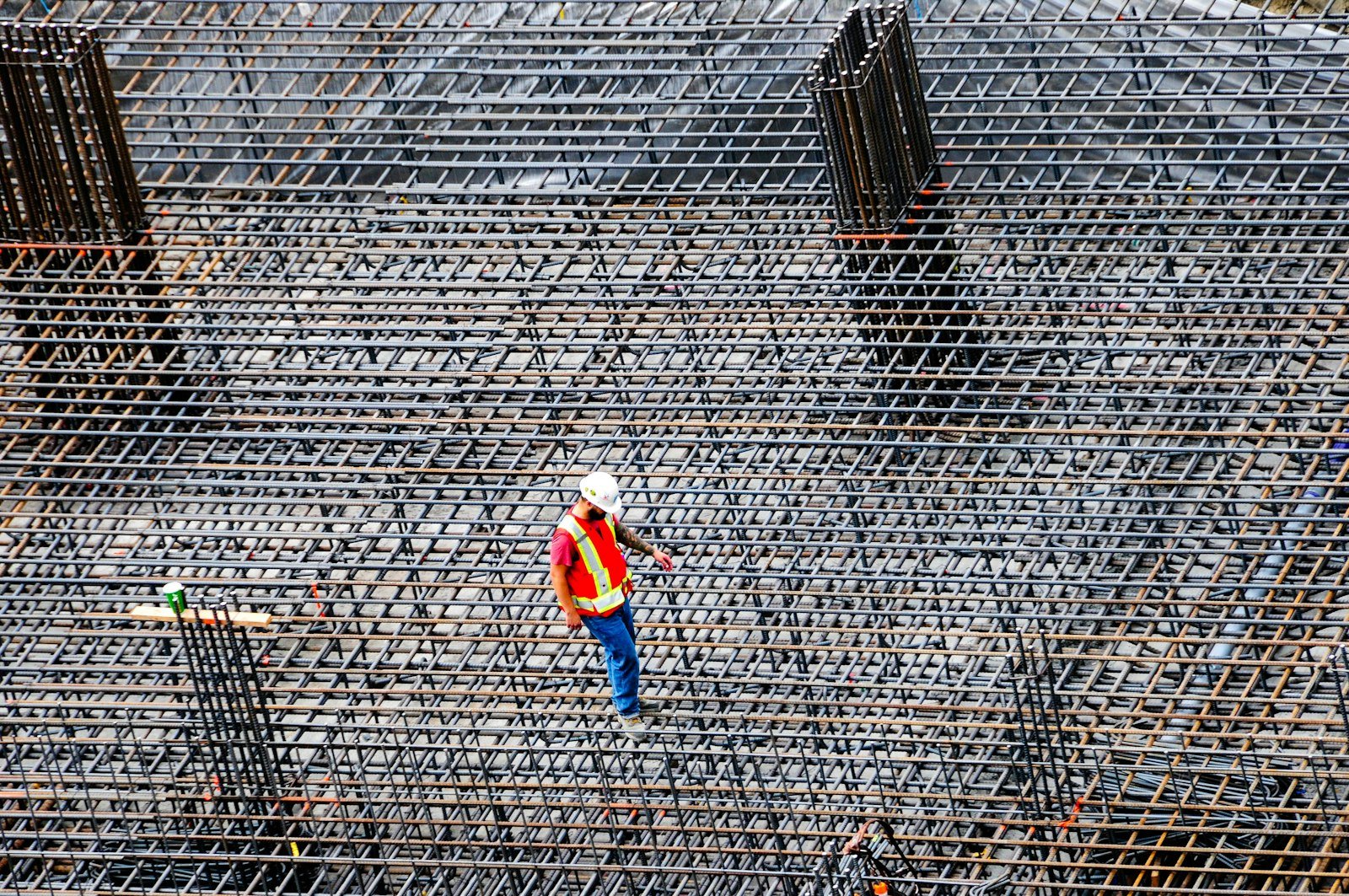 Worker inspecting rebar on a building site